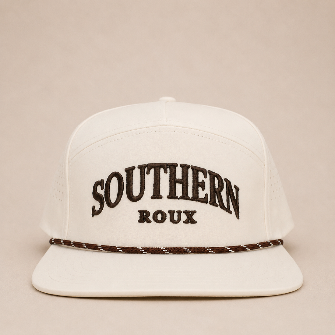 White seven-panel Southern Roux cap with arched embroidery and patterned rope detail.