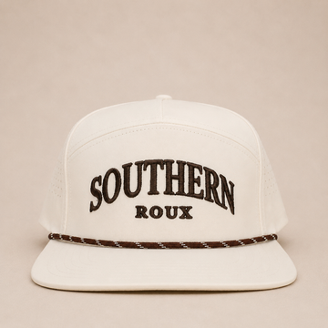 White seven-panel Southern Roux cap with arched embroidery and patterned rope detail.