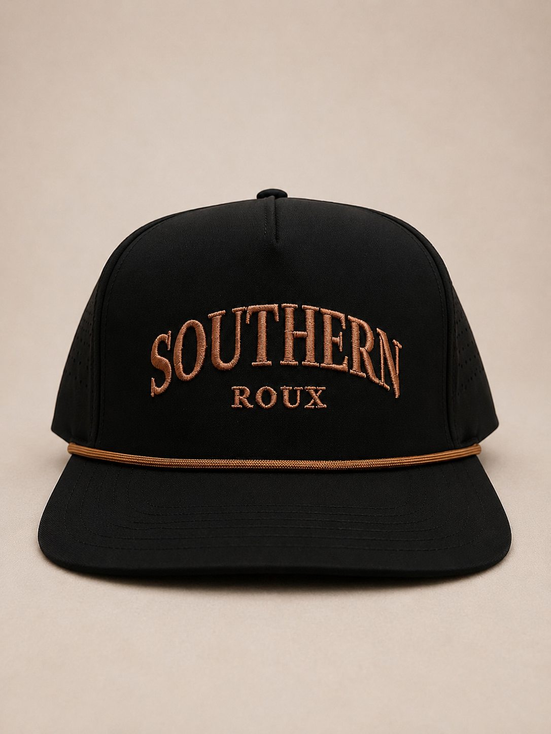 Black five-panel Southern Roux cap with arched embroidery and tan rope detail.