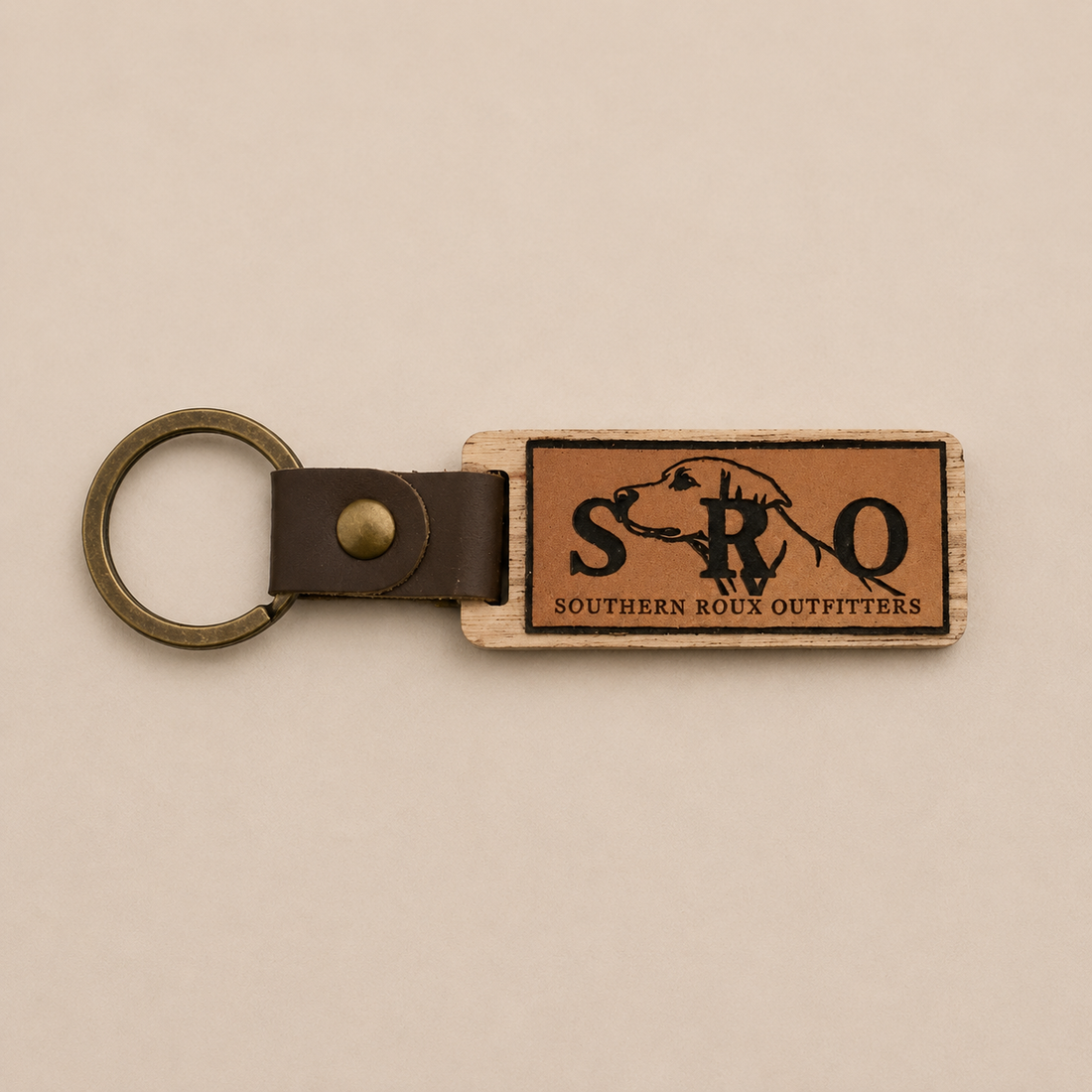 Brown leather SRO key chain with metal ring and rectangular logo patch.