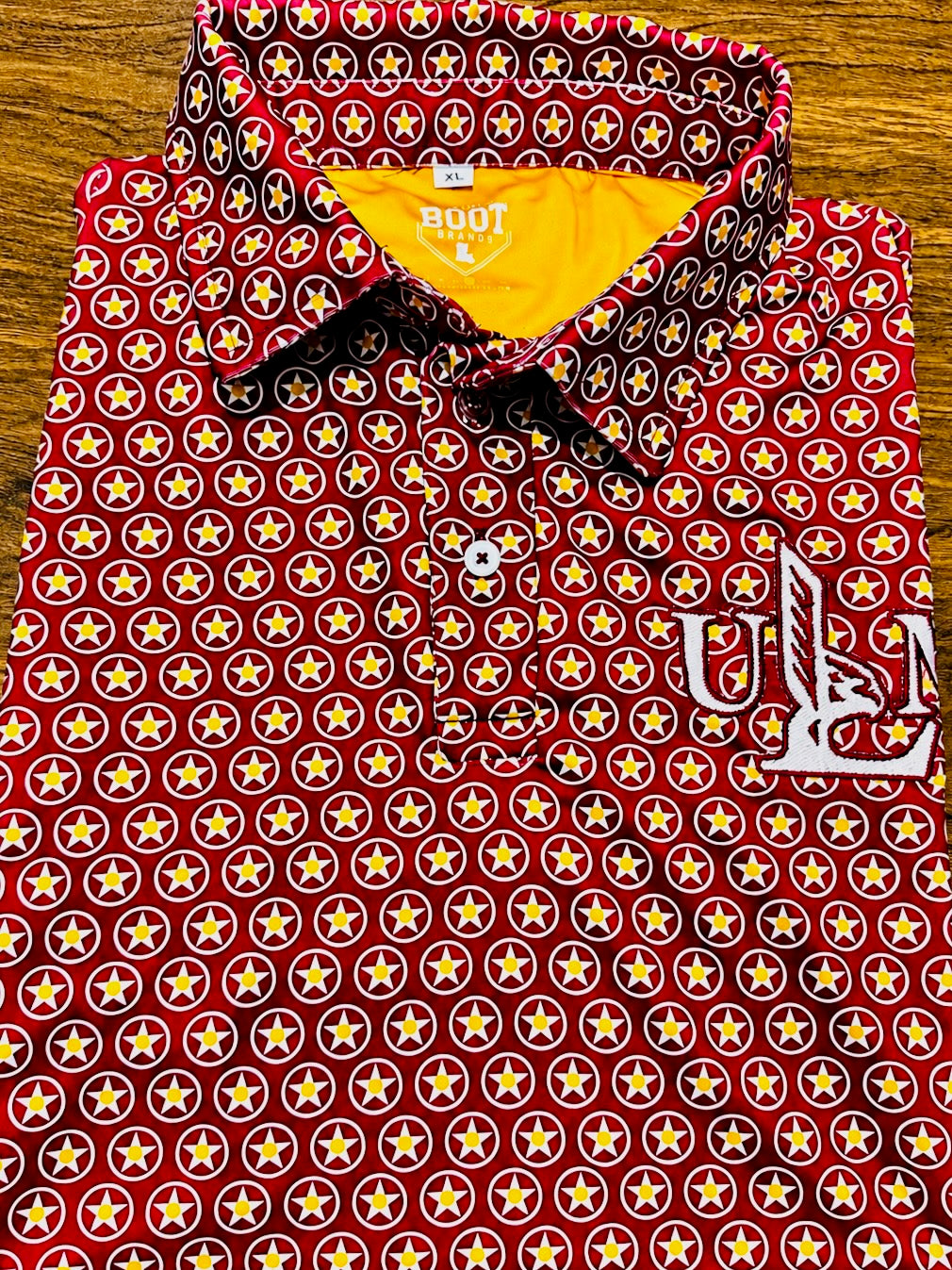 Maroon ULM Athletic Dri Fit Polo with repeating star pattern and embroidered ULM chest mark.