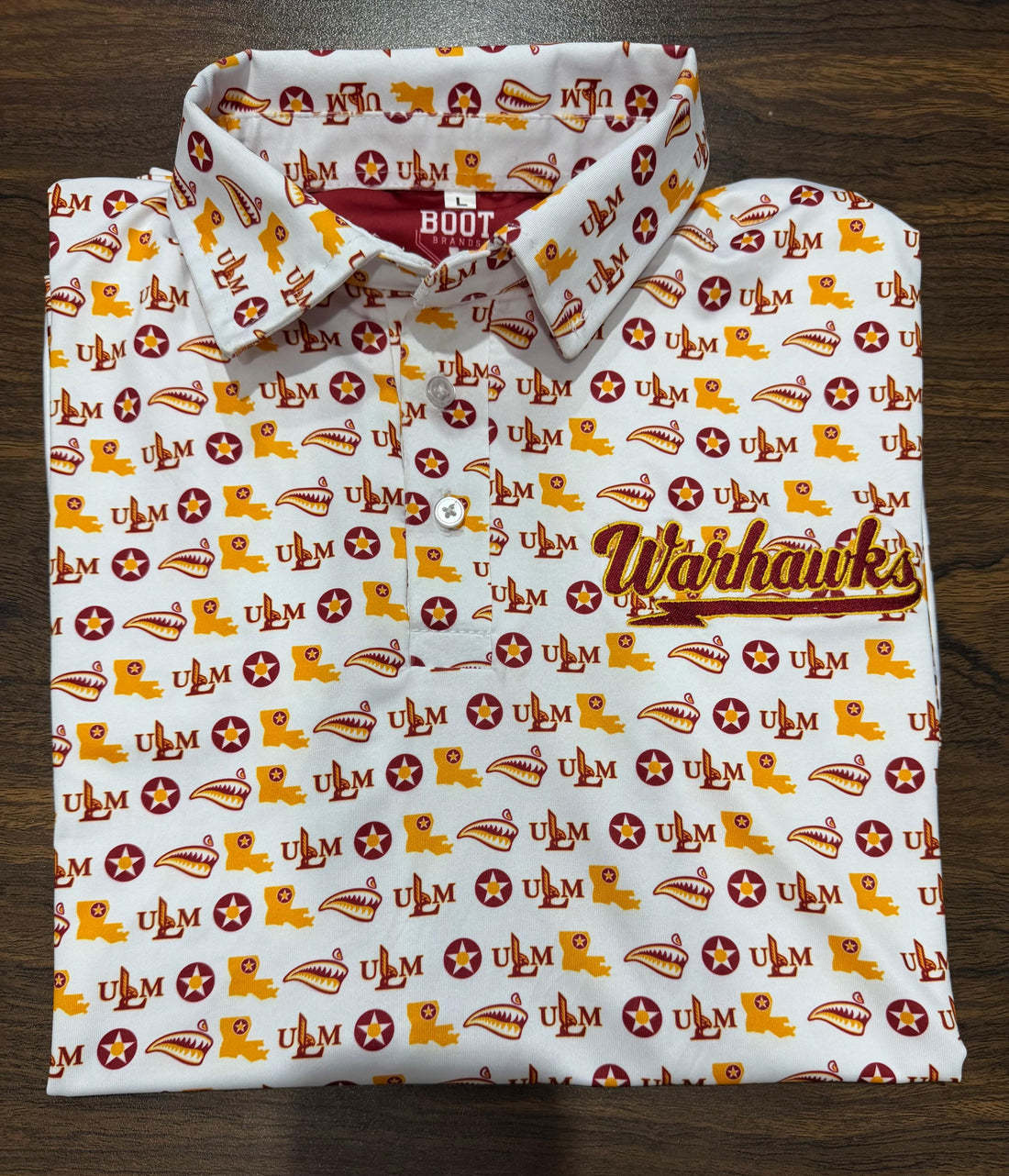 White ULM Athletic Dri Fit Polo with repeating ULM pattern and embroidered Warhawks chest script.
