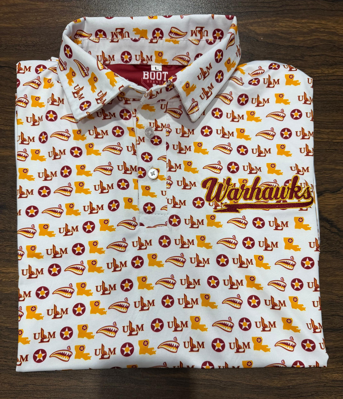 White ULM Athletic Dri Fit Polo with repeating ULM pattern and embroidered Warhawks chest script.